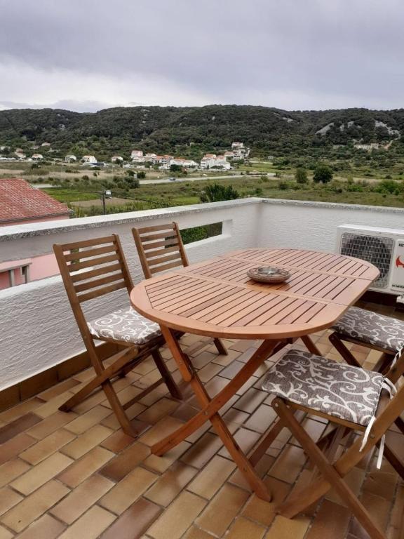 a wooden table and two chairs on a balcony at Apartment Ani in Supetarska Draga