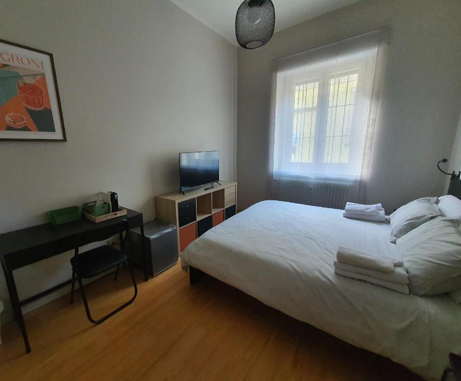 a bedroom with a bed and a television and a window at Room - Garden - private bathroom in Turin