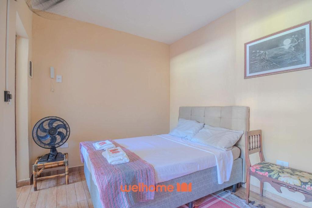 a small bedroom with a bed and a chair at Casa em São Sebastião a 5 min da Praia in São Sebastião