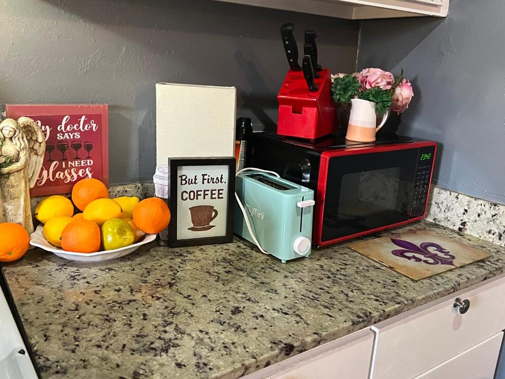 a kitchen counter with a microwave and a bowl of fruit at Blue Beauty located by LSU in Baton Rouge