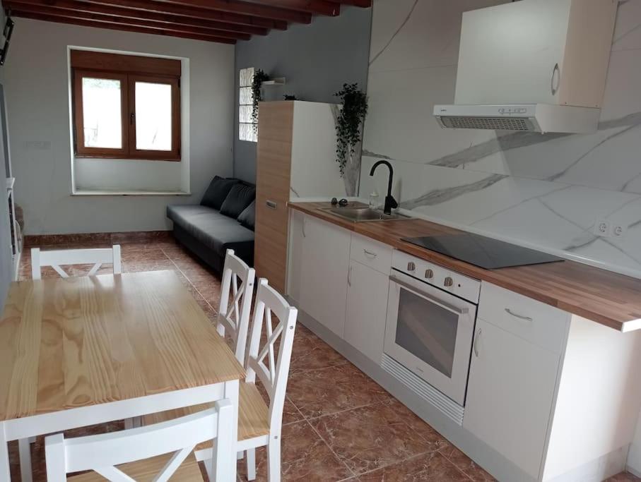 a kitchen and living room with a table and a couch at La Herrería de Somo in Somo