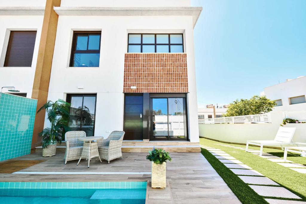 a white house with a swimming pool in front of it at Casa Naranja in Pilar de la Horadada