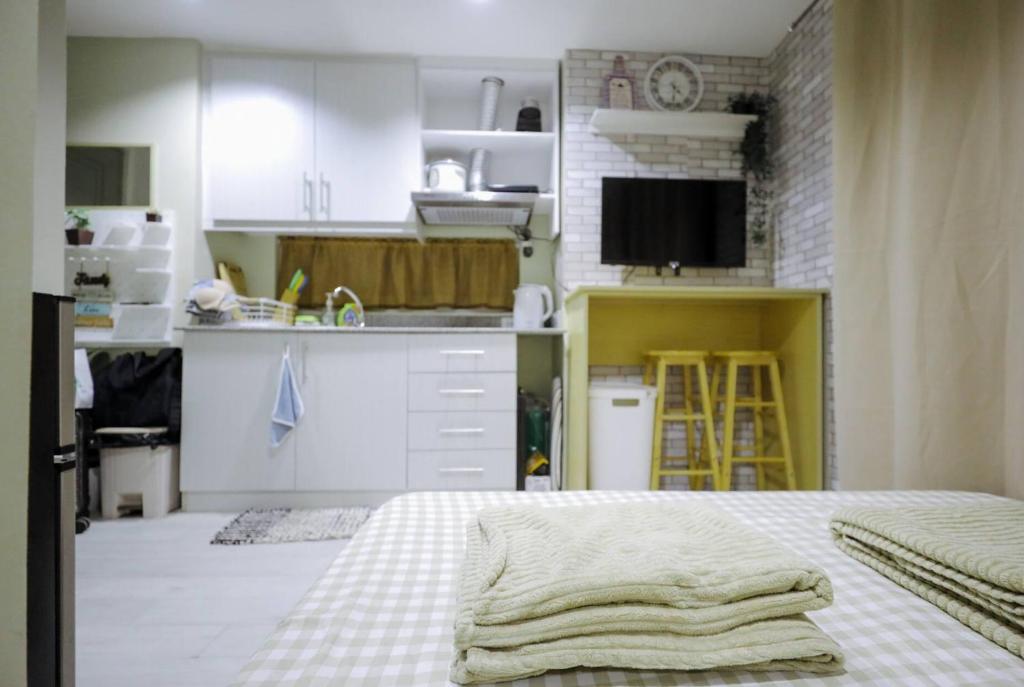 a kitchen with white cabinets and a bed in a room at Cityscape Grand in Cebu City
