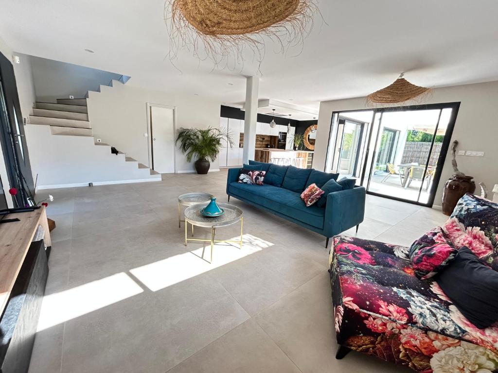 un salon avec un canapé bleu et une table dans l'établissement Villa récente Sanary,piscine, 3 chambres ,proche mer et centre-ville, à Sanary-sur-Mer