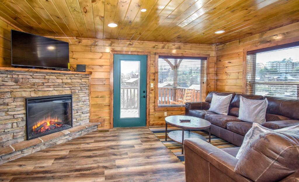 a living room with a couch and a fireplace at Luxury 5-BR Cabin Near Parkway and Dollywood with Game Room and Hot Tub in Pigeon Forge