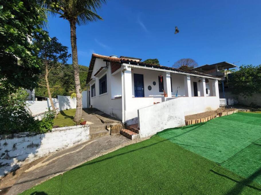 a house with a green lawn in front of it at casa família in Rio de Janeiro