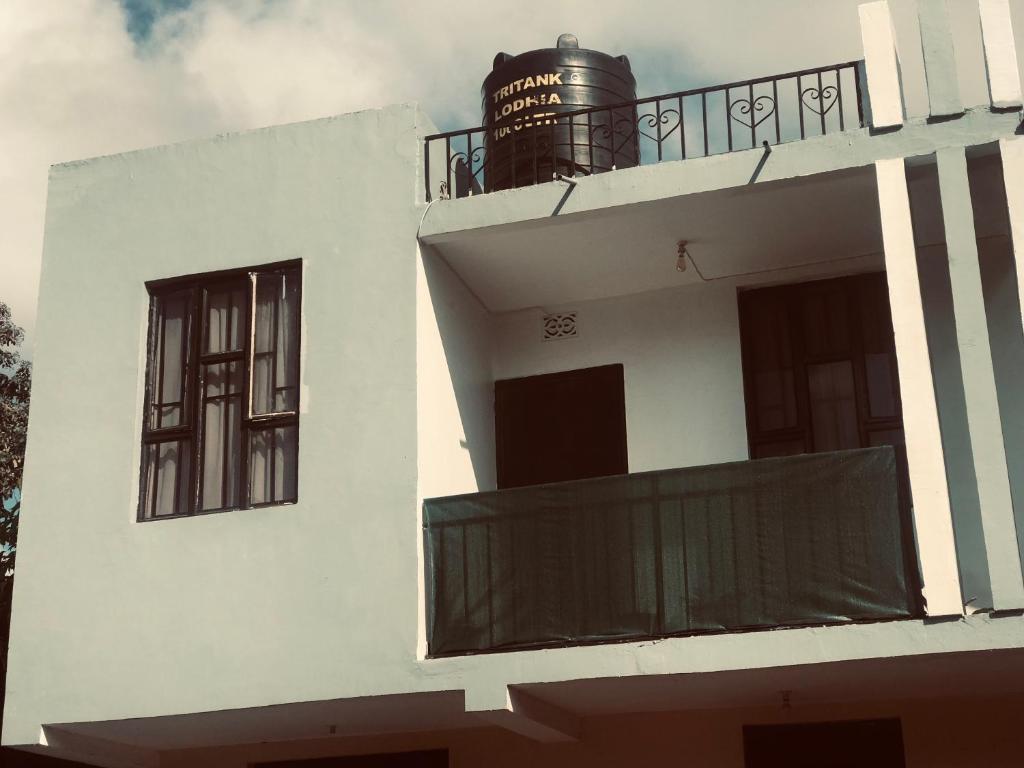 a white building with two windows and a balcony at Bethlehem home in Arusha