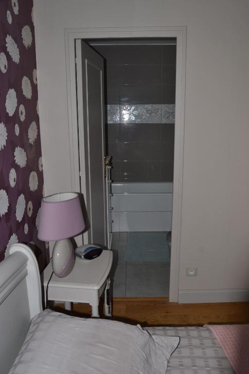 une chambre avec un lit et une table avec une lampe dans l'établissement SAINT Pavace, à Saint-Pavace