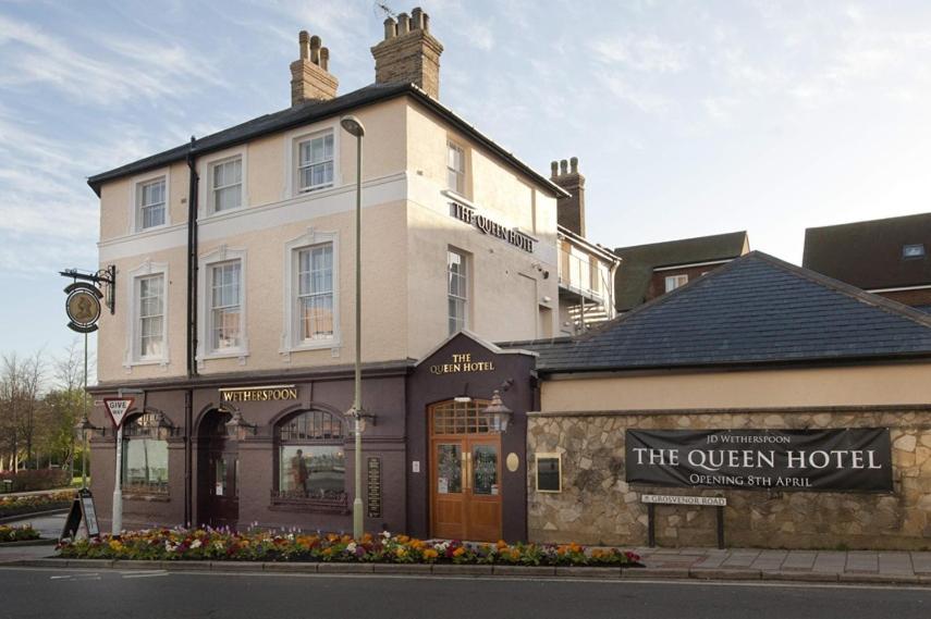 ein Gebäude an der Ecke einer Straße in der Unterkunft The Queen Hotel Wetherspoon in Aldershot