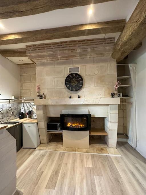 une cuisine avec une cheminée et une horloge murale. dans l'établissement Appartement au Cœur de Tours, à Tours