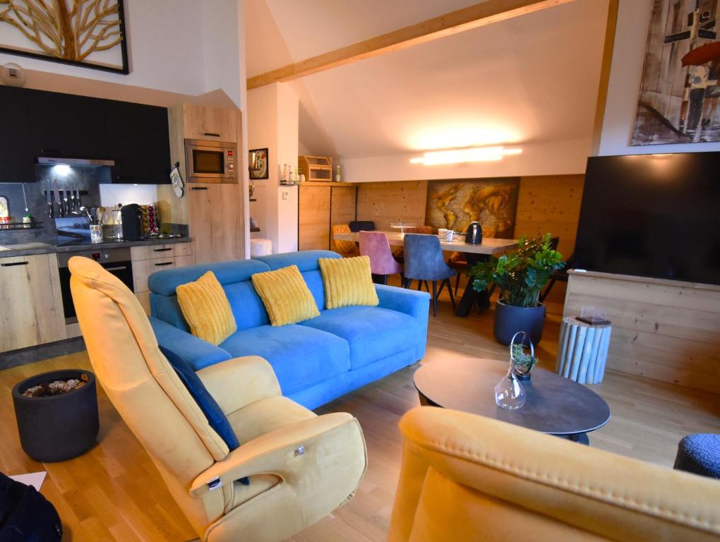 un salon avec un canapé bleu et une table dans l'établissement VAUJANYLOCATIONS - EdelweissD07, à Vaujany