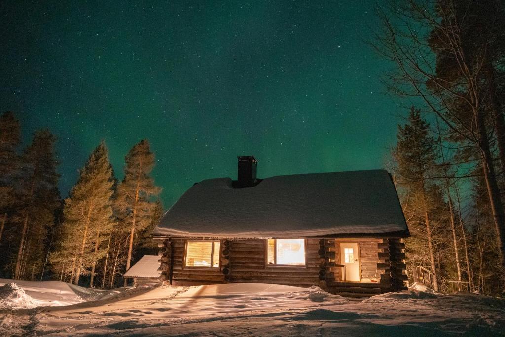 a cabin in the snow at night under the stars at Akolampi cottage in Impiö