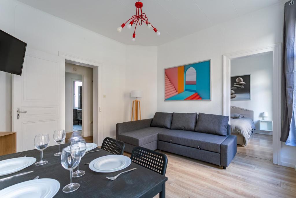 un salon avec un canapé, une table et des chaises dans l'établissement Appartement idéal pour visiter Strasbourg, à Strasbourg