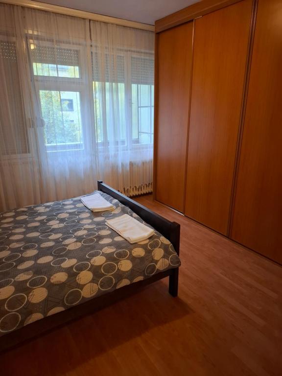 バニャ・ルカにあるMia lux centarのベッドルーム1室(ベッド1台、キャビネット、窓付)
