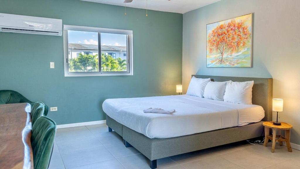 a bedroom with a large bed and two windows at Talk of the Town Inn & Suites - St Eustatius in Oranjestad