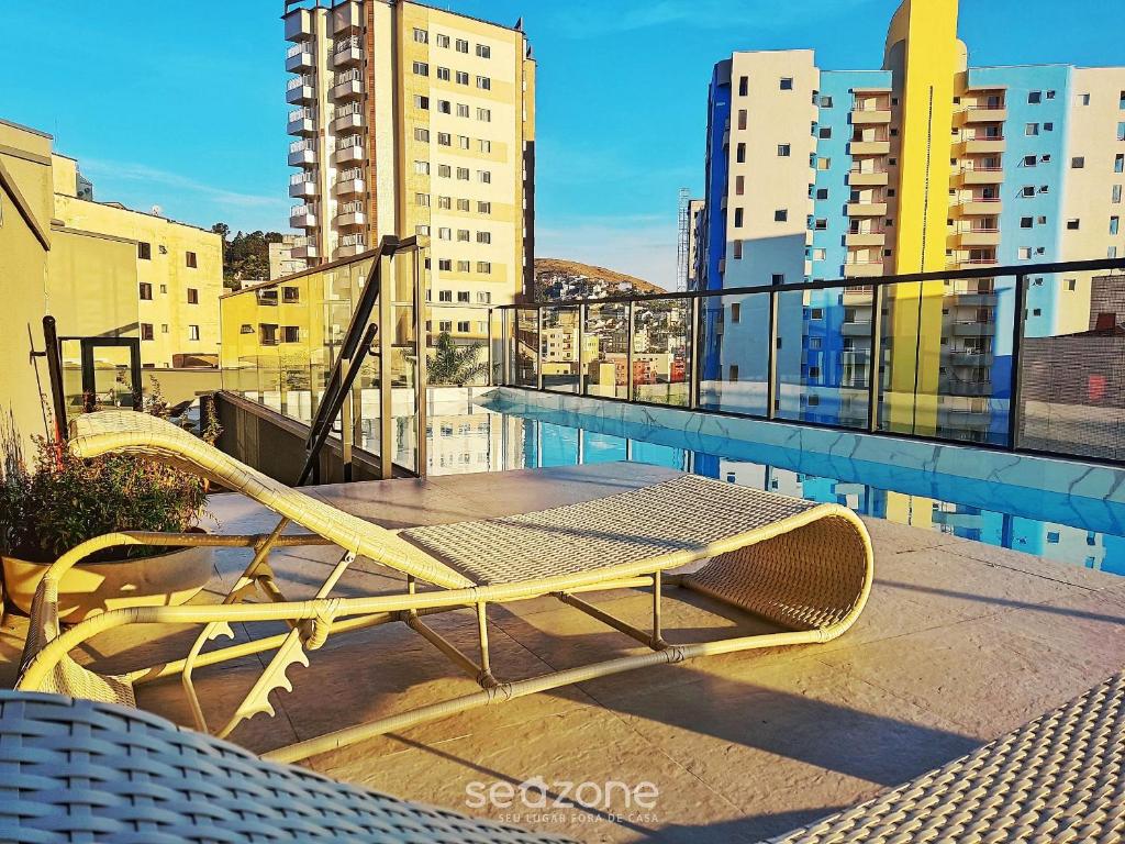 a bench on top of a balcony with buildings at Studio Moderno na Região Central PGO301 in Poços de Caldas