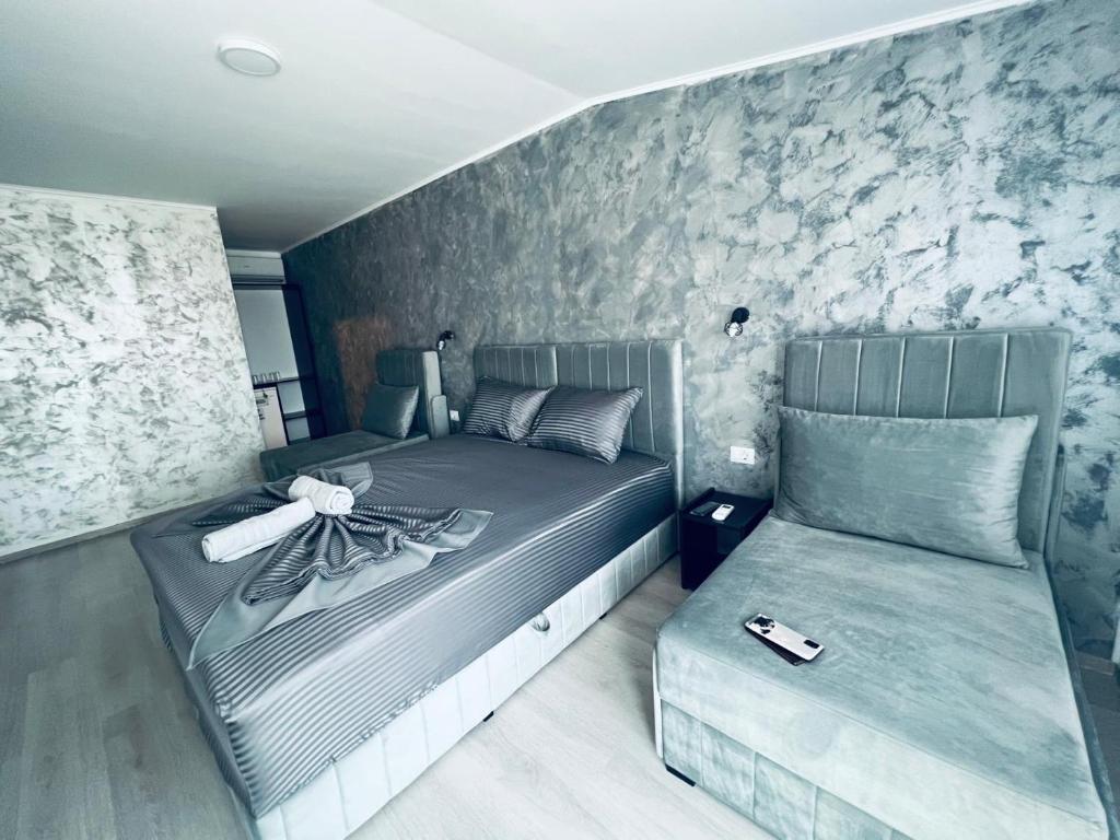 Un dormitorio con una cama y un sofá. en Seba Boutique Hotel, en Constanţa