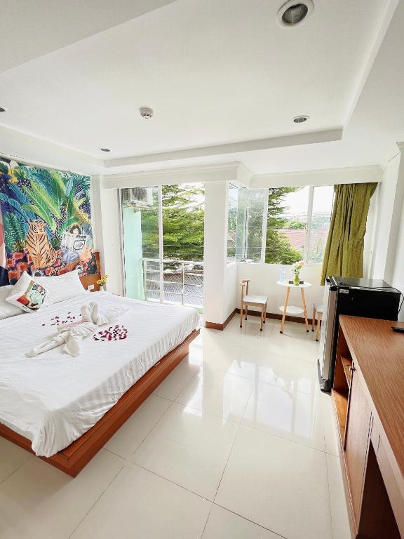 a bedroom with a bed and a large window at Lanting House Phuket in Patong Beach