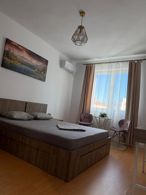 a bedroom with a bed and a large window at Studio Central PCS in Bucharest