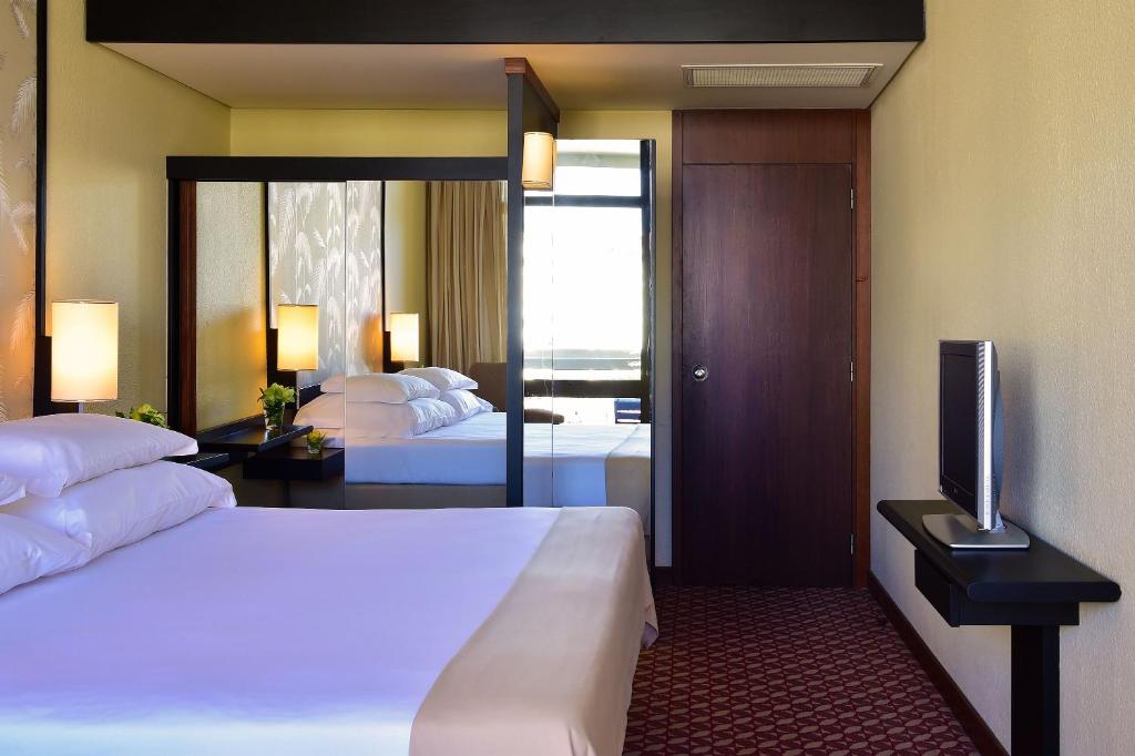 a hotel room with two beds and a television at Pestana Casino Park Hotel & Casino in Funchal