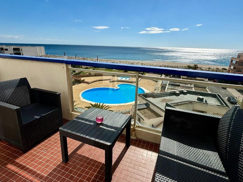 ein Balkon mit Tisch und Stühlen und dem Meer in der Unterkunft *Au Lydia* Appartement vue sur mer, avec piscine. in Le Barcarès