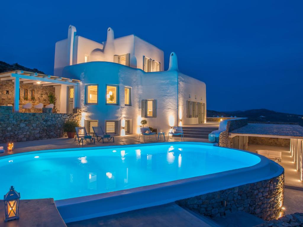 a villa with a swimming pool at night at Velanos Villa in Plintri