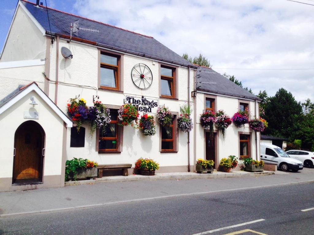 um edifício branco com um relógio em The Nags Head Tredegar em Nant-y-bwch