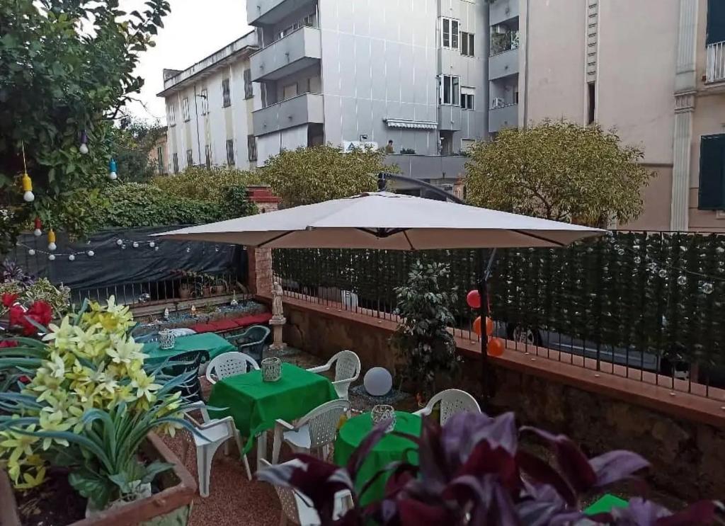 taras ze stołami, krzesłami i parasolem w obiekcie home Joséphine, a due passi dalla Reggia w mieście Caserta