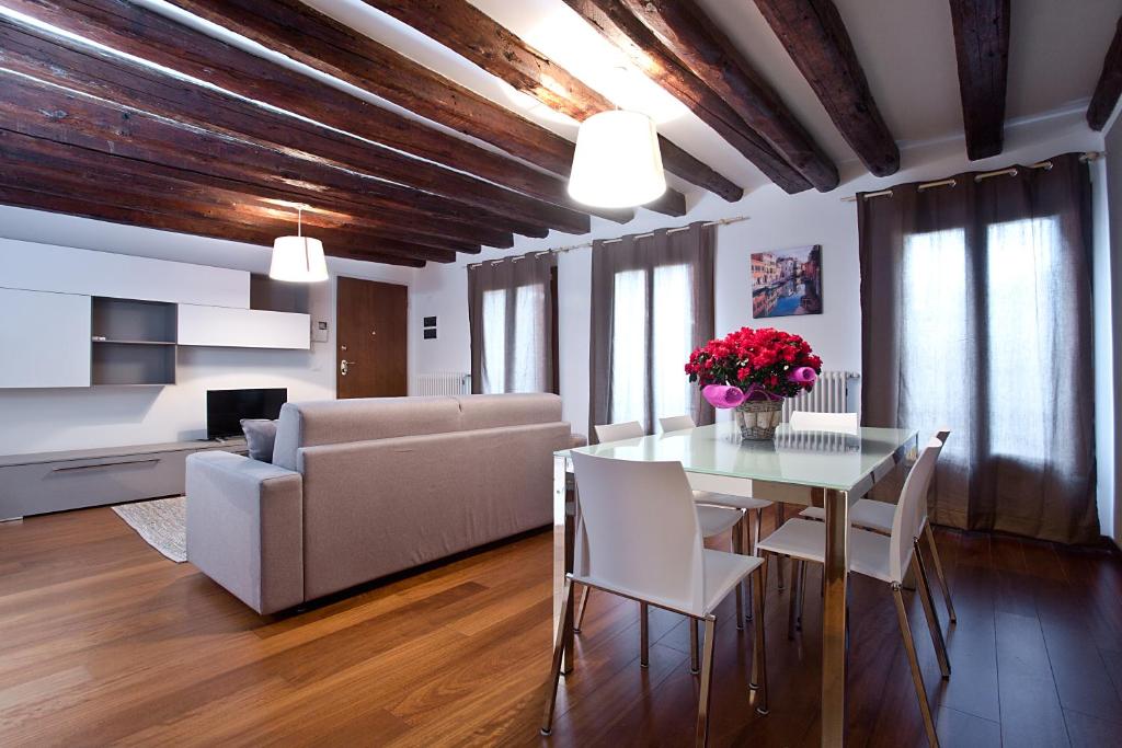 Good Wine Apartments في البندقية: غرفة معيشة مع طاولة وأريكة