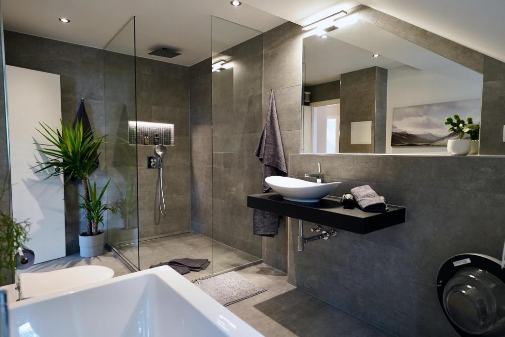 a bathroom with a sink and a tub and a mirror at EDLER WOHNRAUM Noble Stadtoase mit Boxspringbett, Kaffeevollautomat & Parkplatz in Zwickau