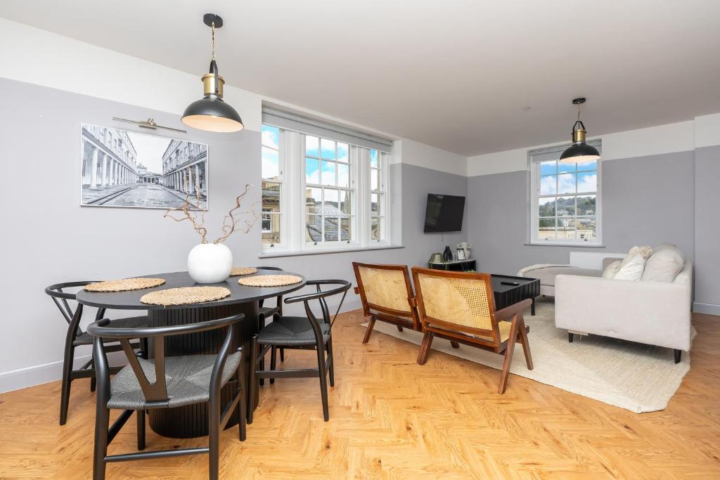 a dining room and living room with a table and chairs at Bath Street Penthouse in Bath