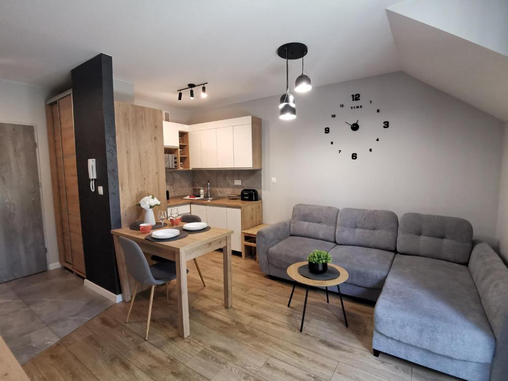 a living room with a couch and a table at Apartament Turkusowy in Karpacz