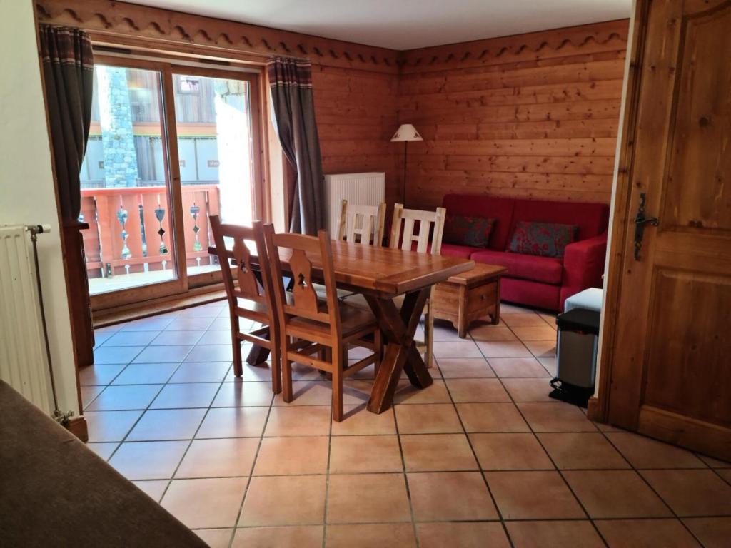 une salle à manger avec une table, des chaises et un canapé dans l'établissement Résidence Les Alpages de Reberty - maeva Home - Appartement 3 pièces 6 personnes - Sélection MAE-4144, aux Menuires