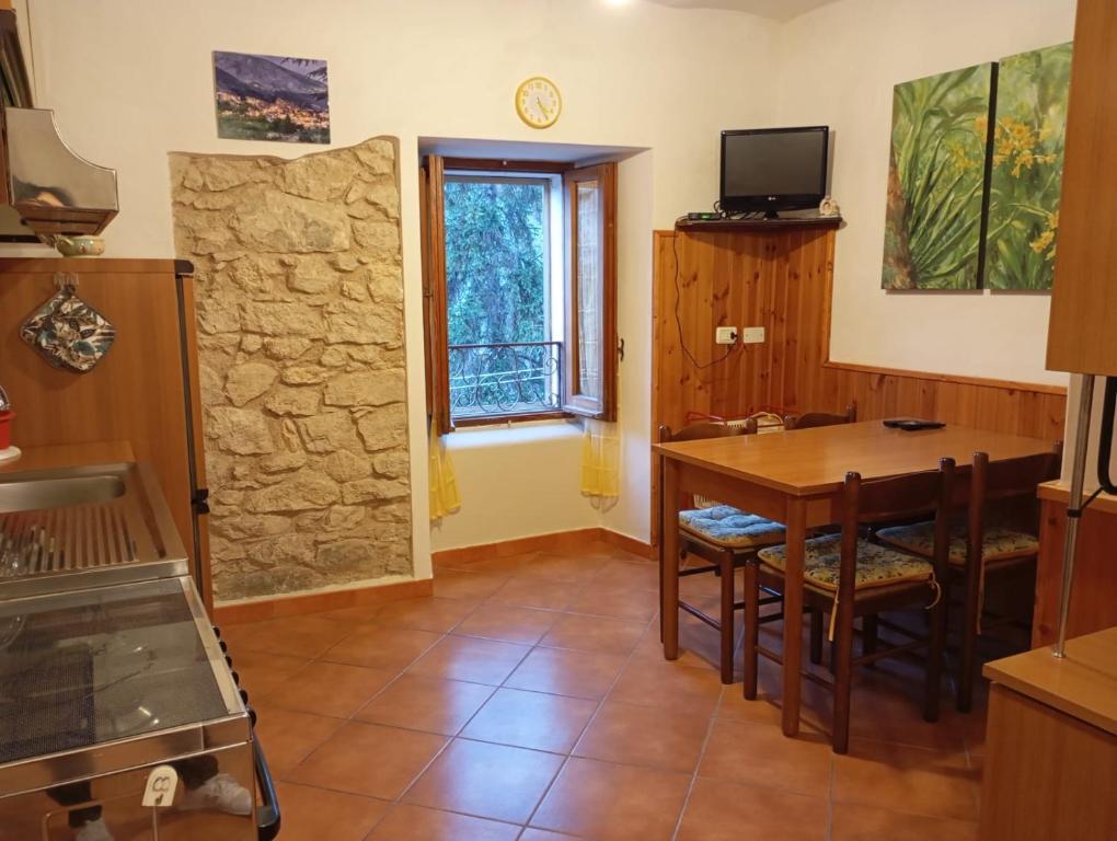 a kitchen with a dining room table and a window at La casetta di Anna in Villalago