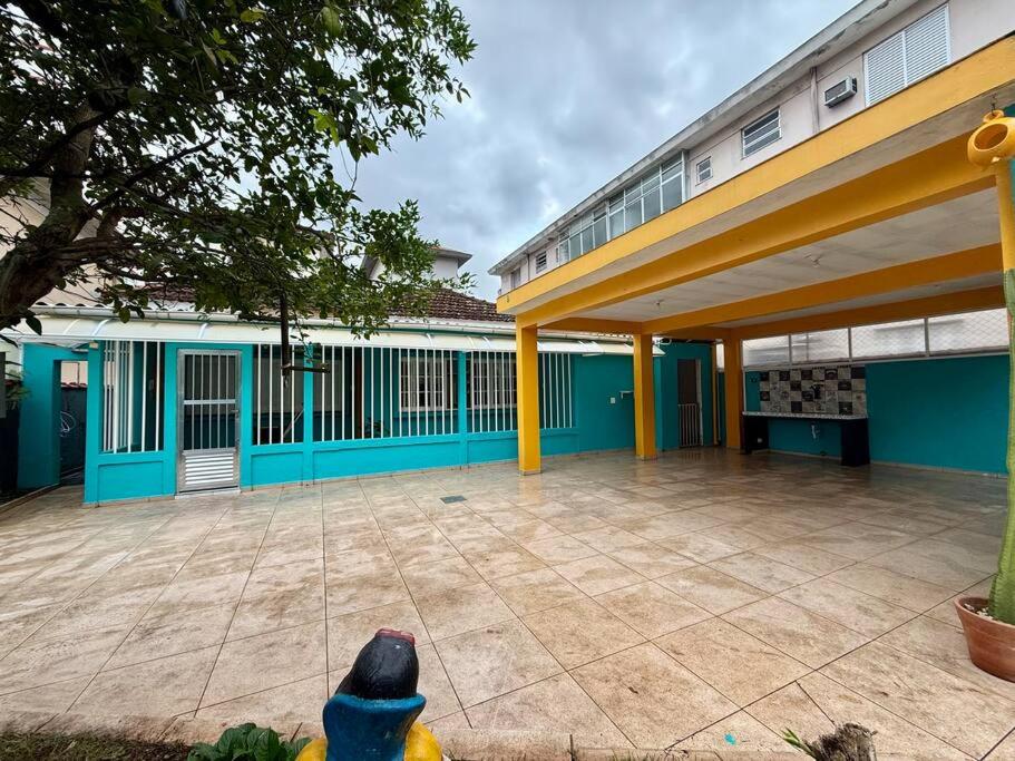 Casa na Vila No coração Gonzaga في سانتوس: مبنى كبير ذو أعمدة زرقاء وصفراء