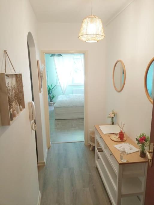 une salle de bain blanche avec un lavabo et un miroir dans l'établissement Appartement Studio Chez Seb & Martin, à Colmar