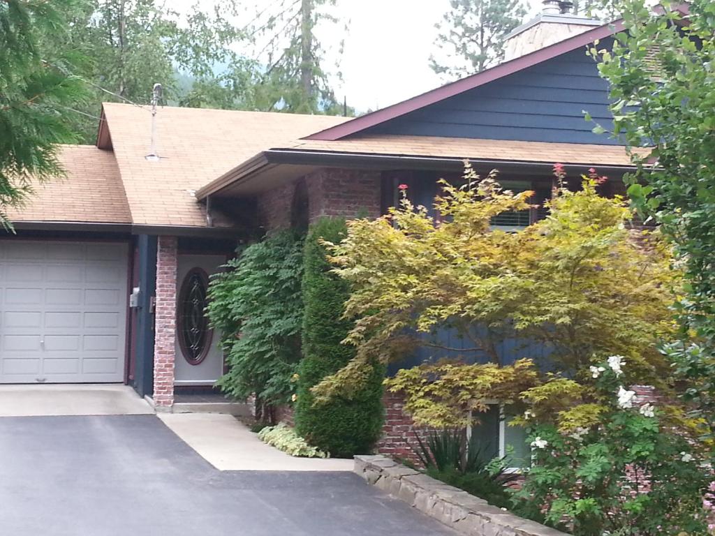 a red brick house with a garage at Creekside B&B in Nelson