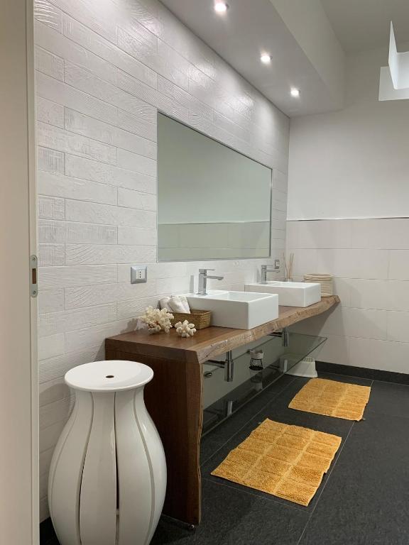 une salle de bains avec deux lavabos et un grand miroir dans l'établissement Il Giardino di Marta - Villa privata con Piscina, à Contrada Maeggio