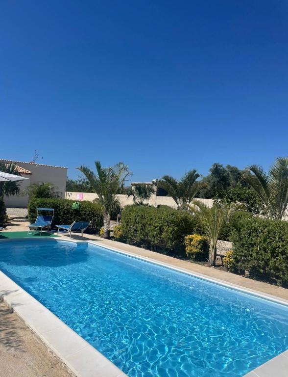 une piscine à l'eau bleue dans un complexe hôtelier dans l'établissement Il Giardino di Marta - Villa privata con Piscina, à Contrada Maeggio