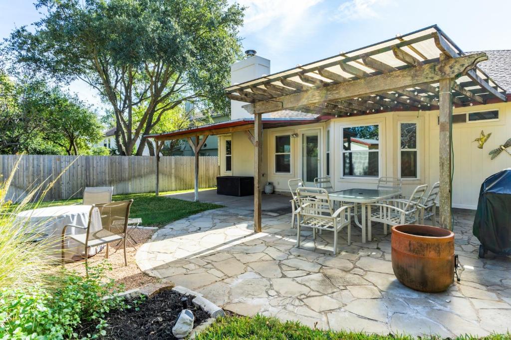 a patio with a table and chairs and a pergola at Cozy 3BR Retreat with Outdoor Dining & BBQ Grill in Pflugerville