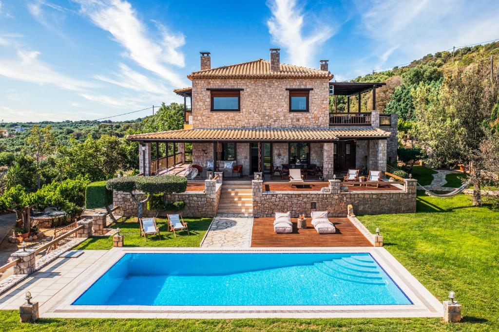 an exterior view of a house with a swimming pool at Villa Vicanti in Pylos