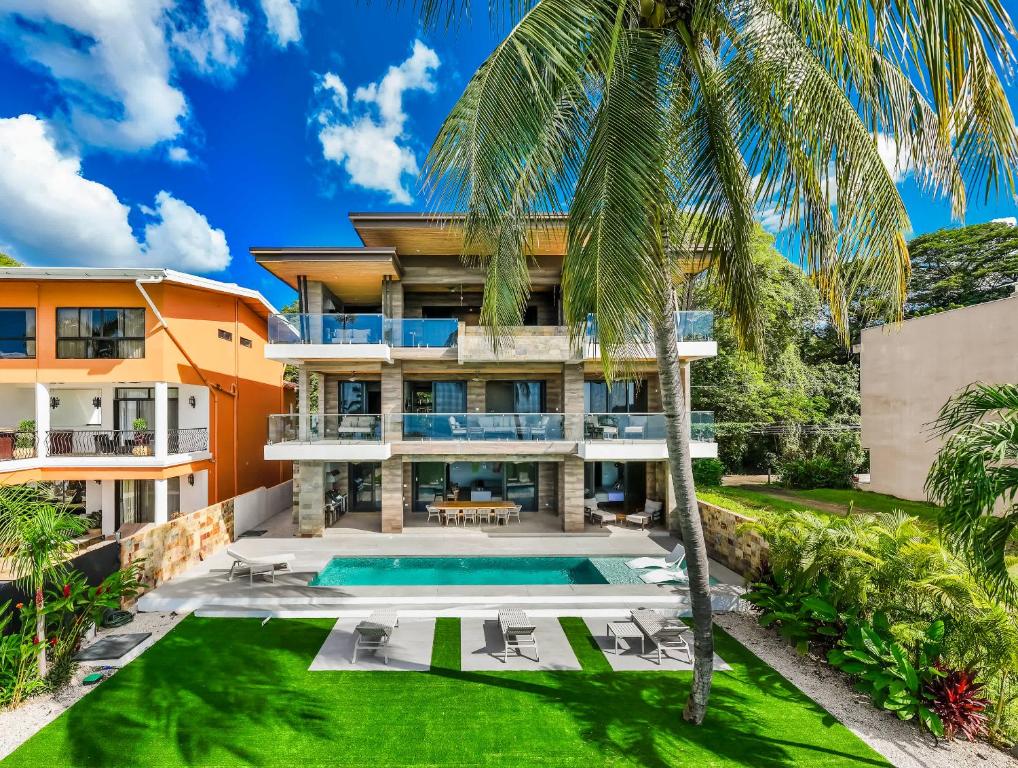 ポトレロにあるBeachfront Pool 5 BD Villaのプールとヤシの木のある家の外観