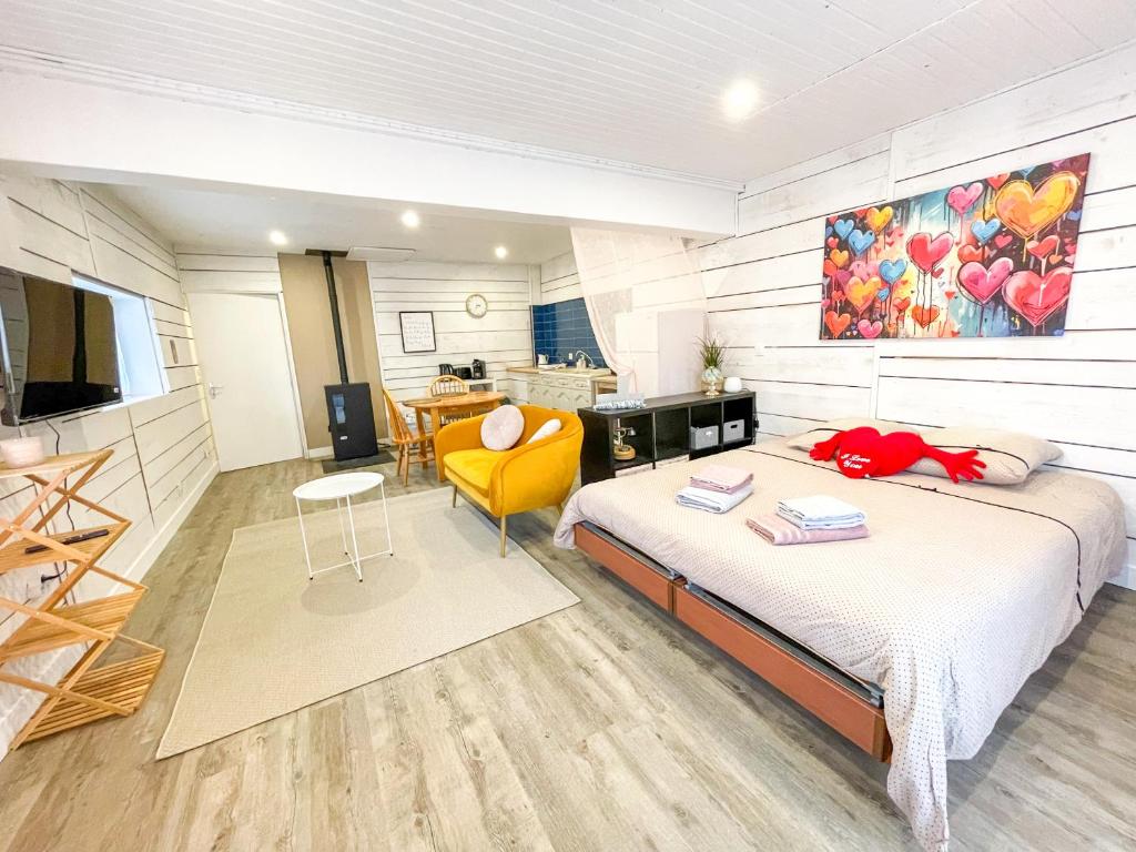 une chambre avec deux lits et une chaise jaune dans l'établissement Le Chalet des Cœurs Enlacés - Wifi Parking, au Chambon-sur-Lignon