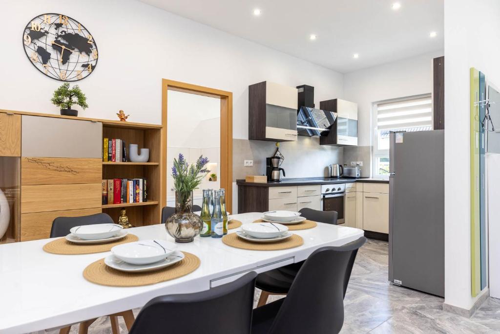 a kitchen and dining room with a white table and chairs at Rheinland Apartments - Stilvolle, moderne Unterkunft mit kostenfreiem WLAN und Parkplatz in Andernach