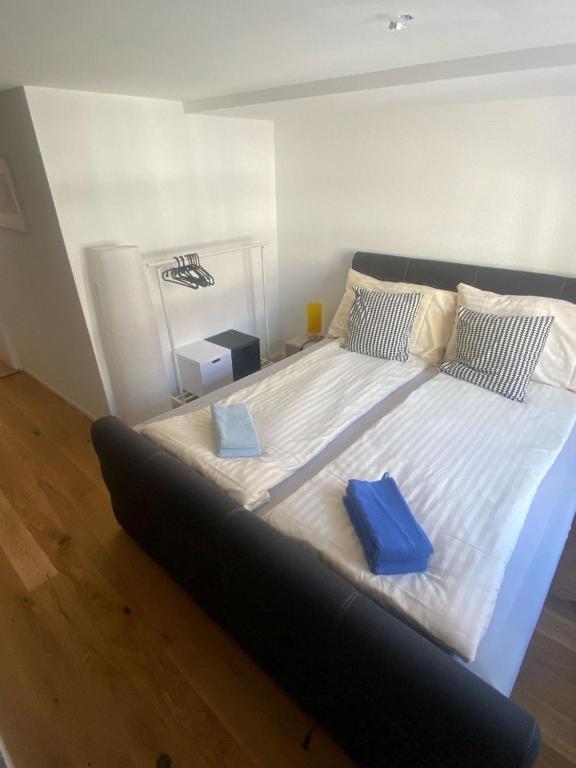 a large bed with two blue pillows on it at Zentrales Schloss Apartment in Arbon