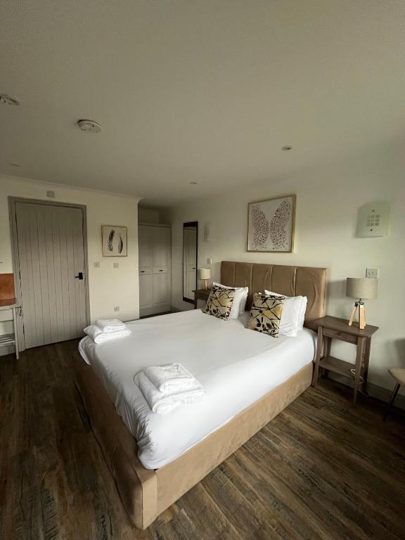 a bedroom with a large bed with white sheets and pillows at Pine, Country chalet located in Pegsdon in Hexton