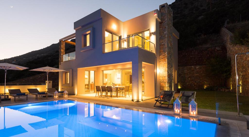 a house with a swimming pool in front of a house at Elounda Luxury Villas in Elounda