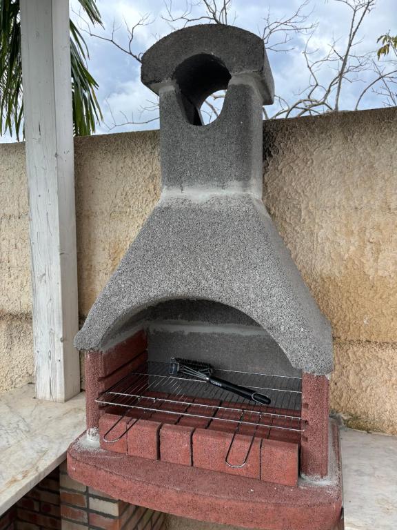 un four en briques avec une spatule à l'intérieur dans l'établissement Il Giardino di Marta - Villa privata con Piscina, à Contrada Maeggio