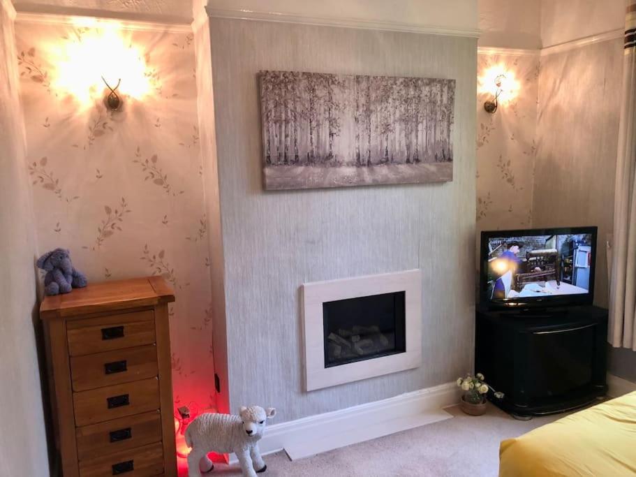 ein Schlafzimmer mit einem Kamin, einem TV und einem ausgestopften Tier in der Unterkunft Cheerful 2 bedroom town house in Lancashire in Chorley