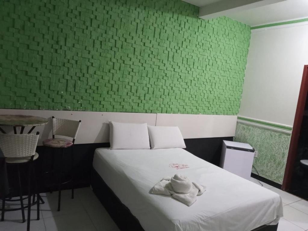 una camera da letto con un letto con una parete verde di Hotel canal hum samambaia a Brasilia